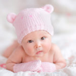 Newborn baby girl in pink knitted bear hat